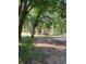Partially cleared lot with mature trees and distant home view at 1921 Smitty Rd, Lady Lake, FL 32159