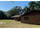 Brick ranch house with covered porch, offering a peaceful, wooded view at 1921 Smitty Rd, Lady Lake, FL 32159