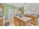 Kitchen with island, light wood cabinets, and views into adjoining living areas at 12176 Se 91St Ave, Summerfield, FL 34491