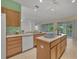 Island kitchen with light wood cabinets and a large island with seating at 12176 Se 91St Ave, Summerfield, FL 34491