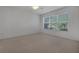 Bright bedroom with neutral carpeting, a large window with blinds, and ceiling fan at 12176 Se 91St Ave, Summerfield, FL 34491