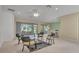 Spacious living area with multiple seating areas, a ceiling fan, and access to the kitchen and patio at 12176 Se 91St Ave, Summerfield, FL 34491