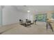 Living room with seating area, a ceiling fan, and access to the kitchen and patio at 12176 Se 91St Ave, Summerfield, FL 34491