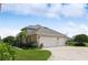 Two-car garage with a driveway and lush landscaping at 29334 David Ct, Tavares, FL 32778