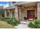 Elegant front porch with brick columns and a wood door at 29334 David Ct, Tavares, FL 32778