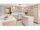 Kitchen with light wood cabinets, white appliances, and an island at 29334 David Ct, Tavares, FL 32778