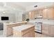 Kitchen with light wood cabinets, white appliances and an island at 29334 David Ct, Tavares, FL 32778