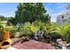 Charming backyard with mature trees, garden area, and patio at 122 Baytree Blvd, Tavares, FL 32778