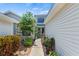Landscaped side yard with walkway leading to entrance at 122 Baytree Blvd, Tavares, FL 32778