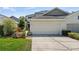 House exterior with attached garage and landscaping at 122 Baytree Blvd, Tavares, FL 32778