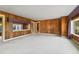 Spacious living room featuring wood paneling and large windows at 304 E Noble Ave, Bushnell, FL 33513