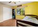 Bedroom with yellow walls, wood floors, and a twin bed at 2270 Washington Rd, Mount Dora, FL 32757
