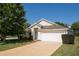 Single-story home with white siding, attached garage, and well-maintained lawn at 24801 Cranes Roost Cir, Leesburg, FL 34748