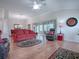 Spacious living room with hardwood floors, comfortable seating, and sliding doors to the lanai at 1751 Ashwood Run, The Villages, FL 32162