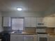Updated kitchen with butcher block countertops, white cabinets, and stainless steel appliances at 1100 E Caroline St # 115, Tavares, FL 32778