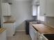 Clean kitchen, featuring butcher block countertops and white cabinets at 1100 E Caroline St # 115, Tavares, FL 32778