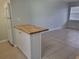 Eat-in kitchen with a butcher block breakfast bar and white cabinetry at 1100 E Caroline St # 115, Tavares, FL 32778