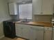 Modern kitchen features butcher block countertops, white cabinets, and new appliances at 1100 E Caroline St # 115, Tavares, FL 32778