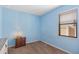 Light blue bedroom with brown carpet and a small nightstand at 9342 Oglethorpe Dr, Groveland, FL 34736