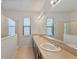 Double vanity bathroom with large mirror and glass enclosed shower at 9342 Oglethorpe Dr, Groveland, FL 34736