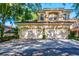 Two-story house with a three car garage and paver driveway at 33 Camino Real # 303, Howey In The Hills, FL 34737
