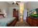 Main bedroom with ensuite bathroom access and large TV at 33 Camino Real # 303, Howey In The Hills, FL 34737