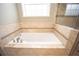 Clean bathroom with a large soaking tub and tile surround at 3554 County Road 216, Oxford, FL 34484