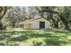 Detached workshop with large roll-up door and covered porch at 3554 County Road 216, Oxford, FL 34484