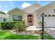 House exterior featuring a light-colored facade, entryway, and landscaping at 1405 W Schwartz Blvd, The Villages, FL 32159