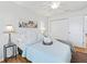 Simple bedroom with light wood floors, a queen-size bed, and a ceiling fan at 1405 W Schwartz Blvd, The Villages, FL 32159