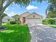 Charming single-story house with a paved driveway and landscaped yard at 1405 W Schwartz Blvd, The Villages, FL 32159