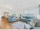 Spacious living room and dining area with light teal sofas and wood floors at 1405 W Schwartz Blvd, The Villages, FL 32159
