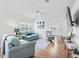 Bright living room with light teal sofas, wood floors, and ceiling fan at 1405 W Schwartz Blvd, The Villages, FL 32159