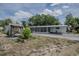 Mobile home exterior with covered porch, shed, and landscaped yard at 1306 Westland Dr, Tavares, FL 32778