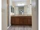 Double vanity bathroom with a large mirror and shower at 12046 Ne 51St Cir, Oxford, FL 34484