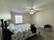Bright bedroom with a queen bed, ceiling fan, and window at 12046 Ne 51St Cir, Oxford, FL 34484
