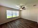 Bright bedroom with hardwood floors and large window at 12046 Ne 51St Cir, Oxford, FL 34484