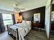 Bedroom with a full-size bed, dark accent wall, and window at 12046 Ne 51St Cir, Oxford, FL 34484