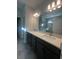 Bathroom with double vanity, large mirror, and walk-in shower at 2003 Sunshine Peak Dr, Minneola, FL 34715