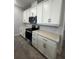 Modern kitchen with white cabinets, quartz countertops and stainless steel appliances at 2003 Sunshine Peak Dr, Minneola, FL 34715