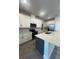 Modern kitchen with island, white cabinets, and stainless steel appliances at 2003 Sunshine Peak Dr, Minneola, FL 34715