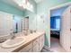 Bathroom with double vanity, view of bedroom, and shower at 172 Seville Dr, Davenport, FL 33837