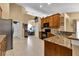 Modern kitchen with stainless steel refrigerator, granite counters, and wood cabinets at 13144 Coldwater Loop, Clermont, FL 34711