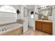 Bathroom with soaking tub, vanity and linen closet at 13144 Coldwater Loop, Clermont, FL 34711