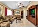 Living room features a comfortable seating area, wood entertainment center, and ceiling fan at 13144 Coldwater Loop, Clermont, FL 34711