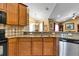 Kitchen boasts granite countertops, stainless steel dishwasher, and wood cabinets at 13144 Coldwater Loop, Clermont, FL 34711