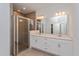 Modern bathroom featuring dual vanities, a spacious shower, and white cabinetry at 5840 Springer St, Saint Cloud, FL 34771