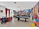 Game room with pool table, arcade games, and Marvel theme at 4189 Paragraph Dr, Kissimmee, FL 34746