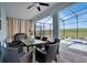 Covered patio with dining table and chairs overlooking the pool and lake at 4189 Paragraph Dr, Kissimmee, FL 34746