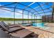 Relaxing pool and spa with lake view, screened enclosure, and lounge chairs at 4189 Paragraph Dr, Kissimmee, FL 34746